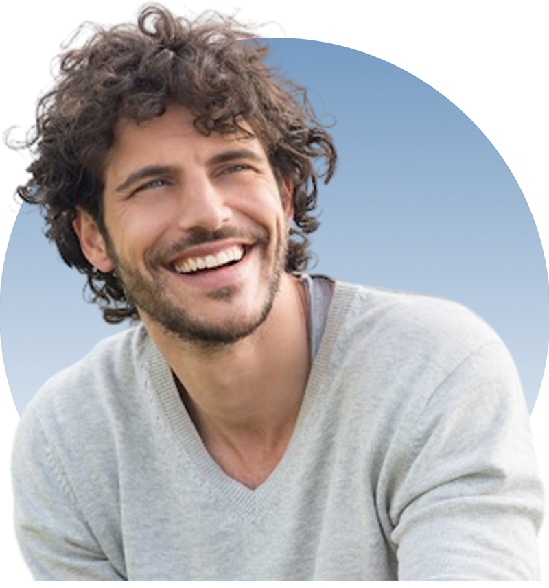 A man with curly hair smiling for the camera.