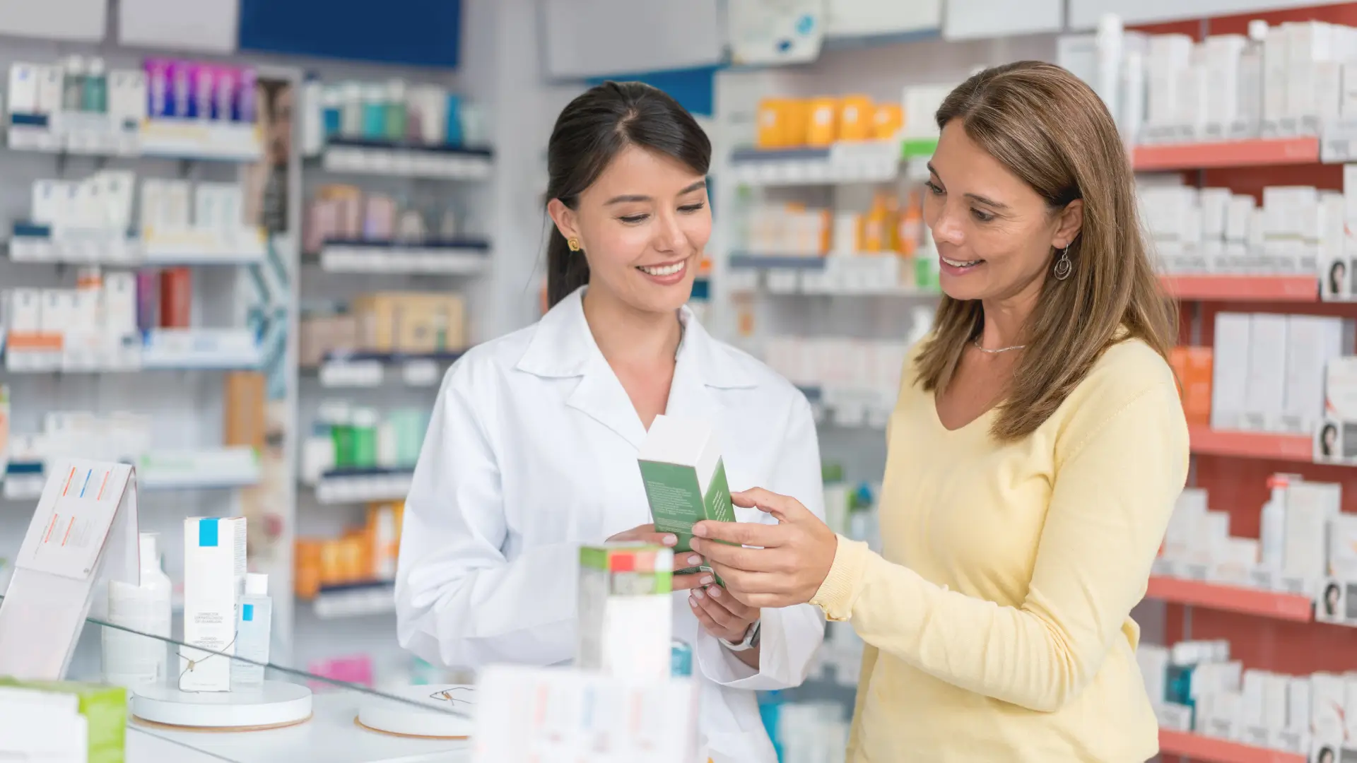 Pharmacist assisting customer with product selection.